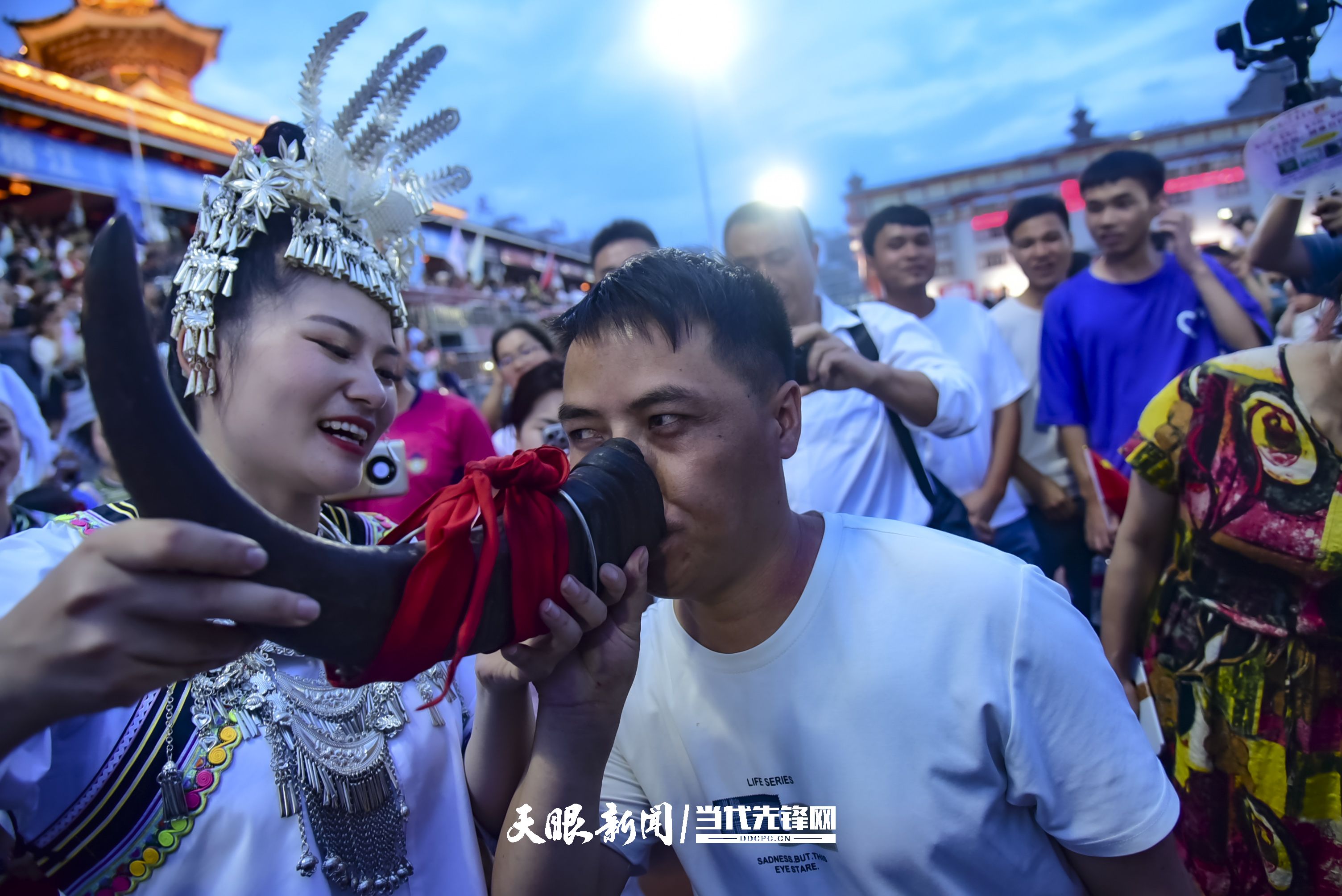 村超現(xiàn)場(chǎng)，當(dāng)?shù)厝罕娤蜻h(yuǎn)道而來(lái)的游客敬酒。 潘邵平 攝.jpg